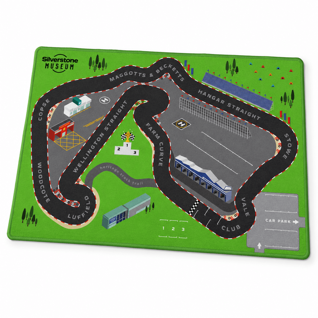 Rectangular Silverstone Museum children’s play rug featuring a colourful illustrated racing circuit, grandstand, pit garages, podium, emergency buildings and car park.