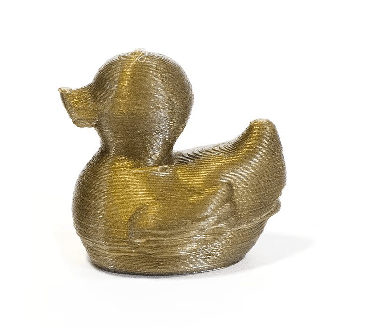 The finished rubber duck after 3D printing, in gold PLA filament, showing the printed layer lines